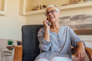Senior woman having a mobile phone conversation while resting at home