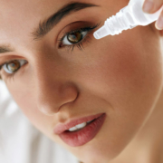 closeup of a woman putting eyedrops in