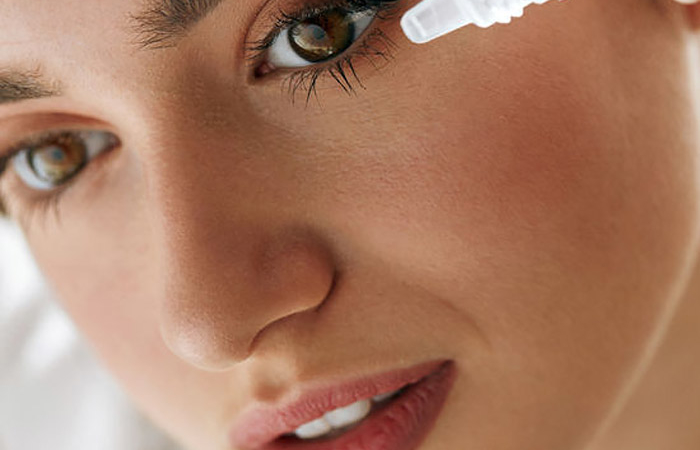 closeup of a woman putting eyedrops in