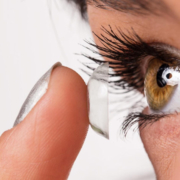 closeup of a woman putting a contact lens in her eye