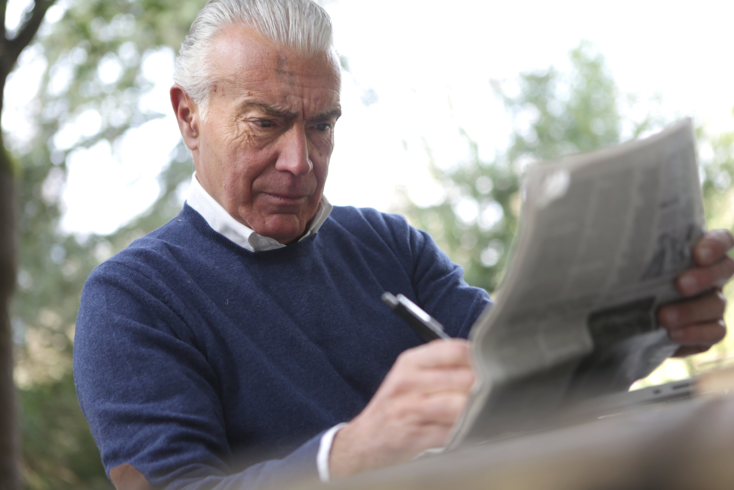 man in blue sweater struggling to read