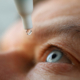 Man drops eye drops install lenses, moisturizing. Preservation and solution vision problems. Eye diseases are recognized. Drops before putting on lenses or before removing at end day