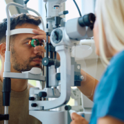 Image of a young man getting his eyes examined by a female optometrist