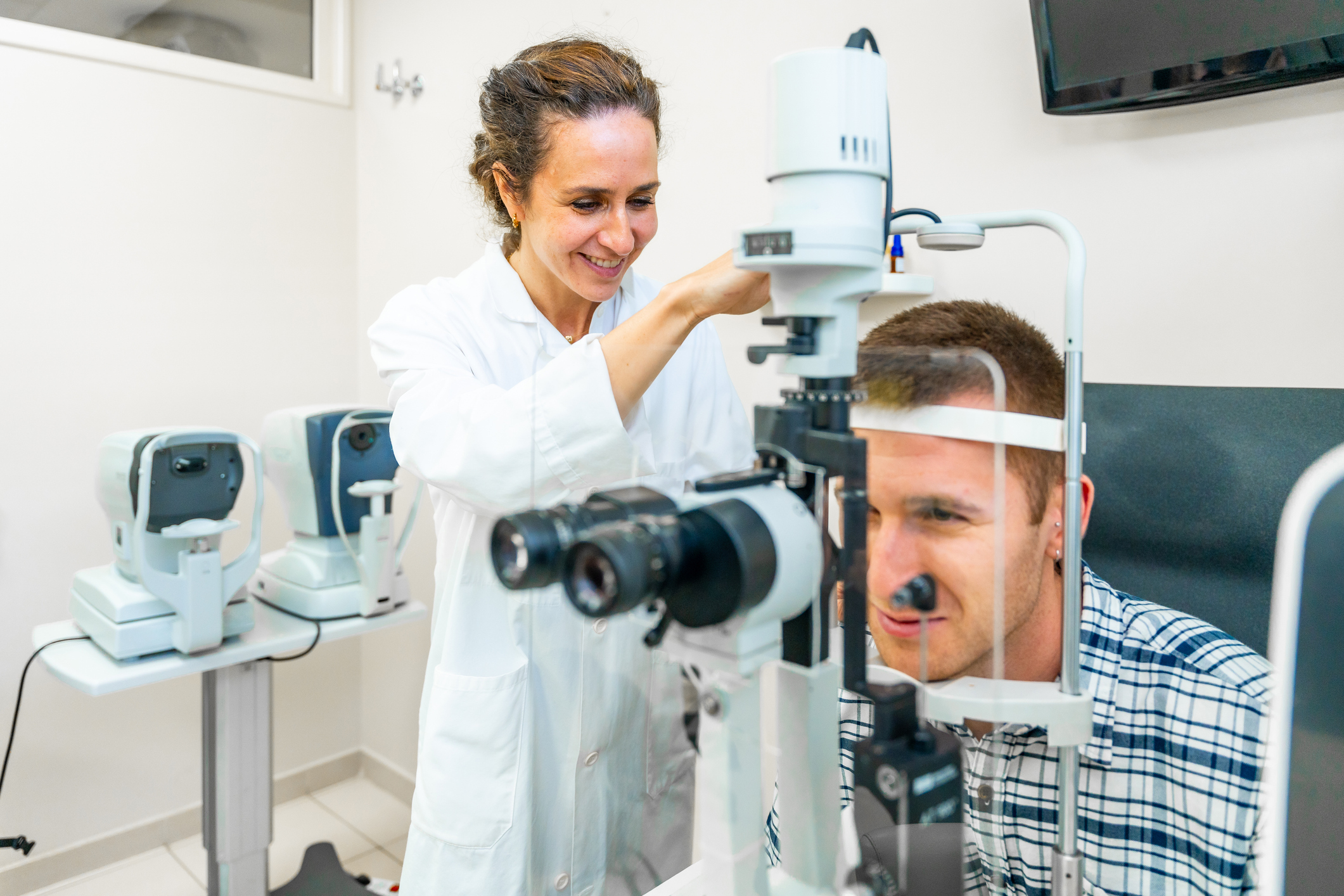 Image of an eye doctor performing an exam on a patient.