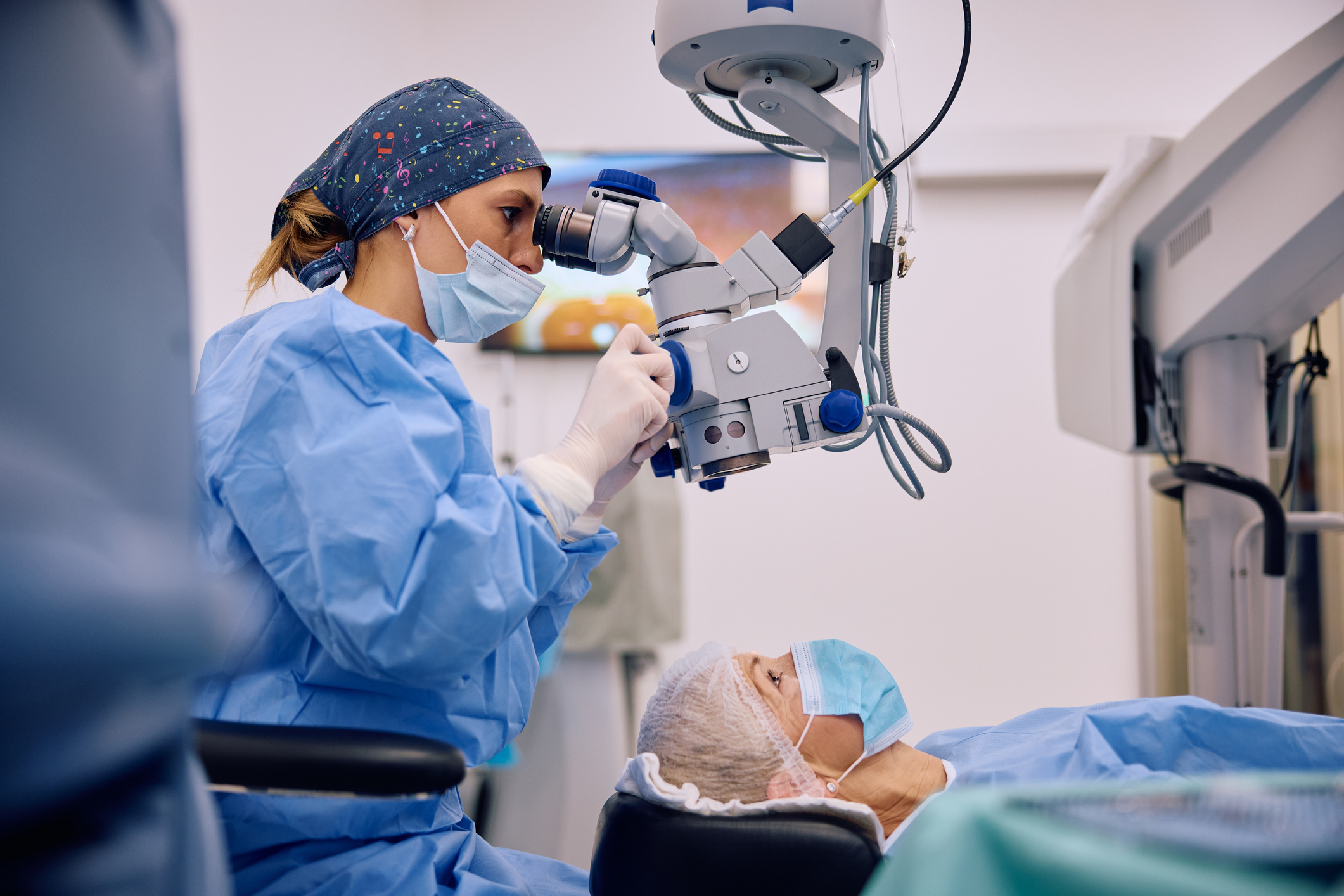 Image of a young eye doctor performing an eye exam on a patient.