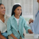 Image of a mom taking her daughter to get an exam exam in the event of hereditary glaucoma.