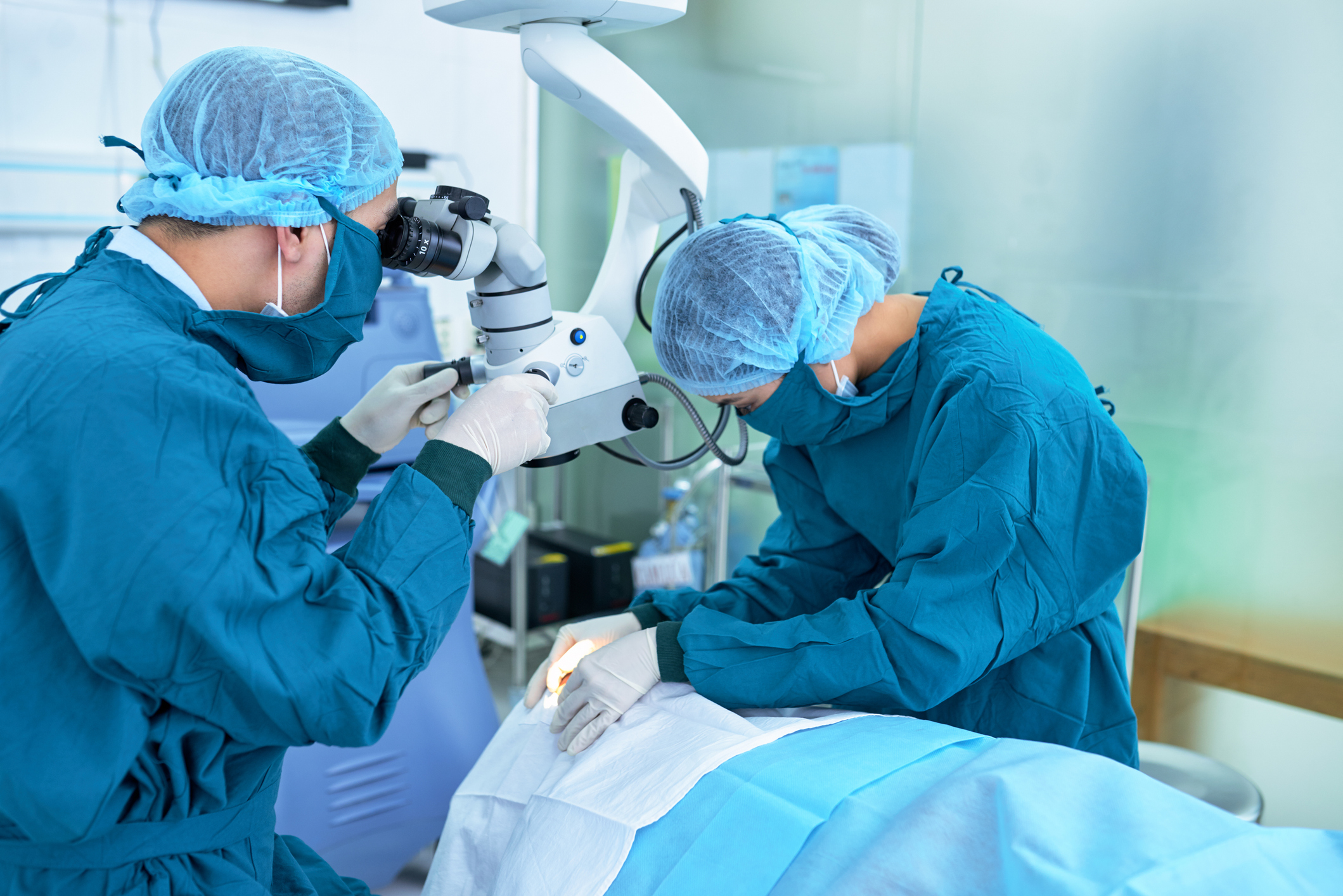 Team of medical worker performing an eye surgery.