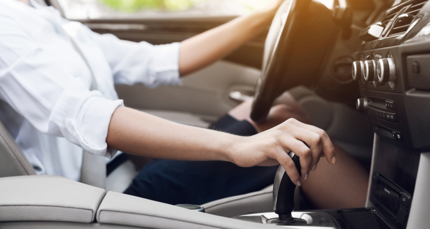 Image of a woman changing gears in her car.
