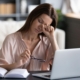 woman itching eyes at laptop