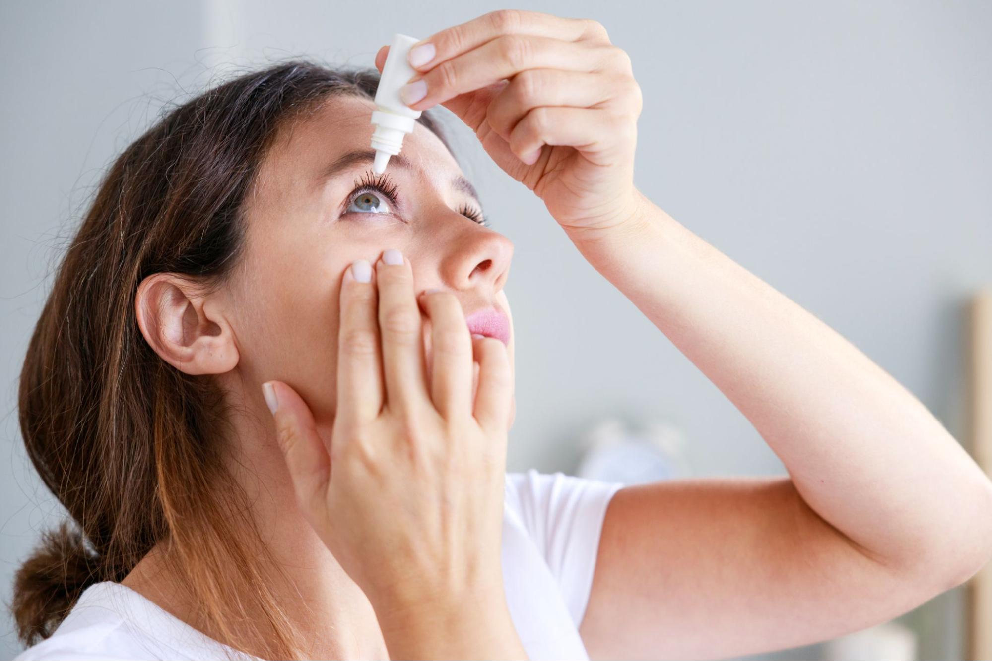 woman putting in eye drops to relieve dry eye