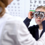 girlvisiting oculist for measuring eyesight with phoropter