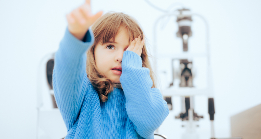 Toddler child pointing to a vision chart during eye check