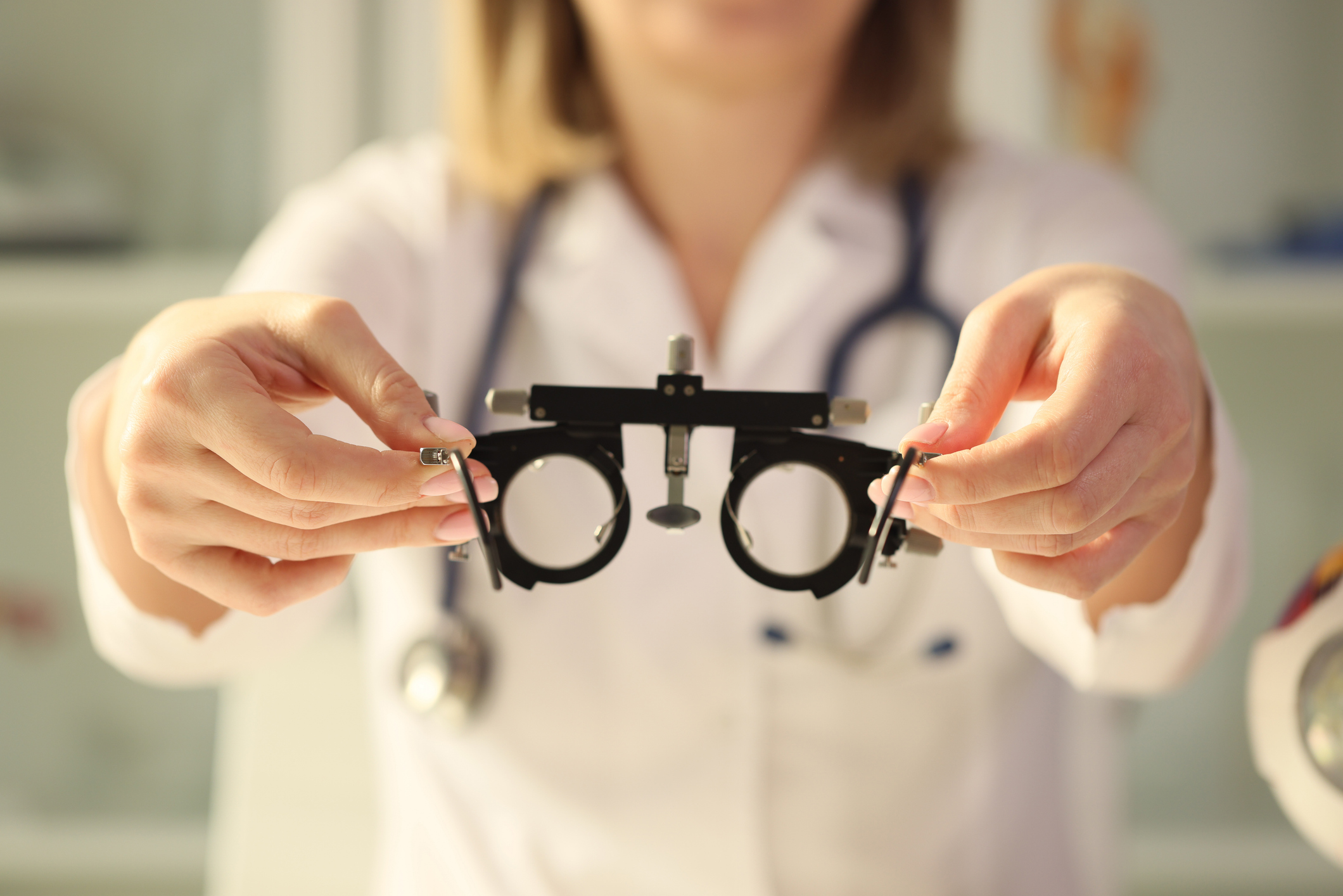 Doctor holds a frame for the selection of lenses, close-up Doctor holds a frame for the selection of lenses, close-up